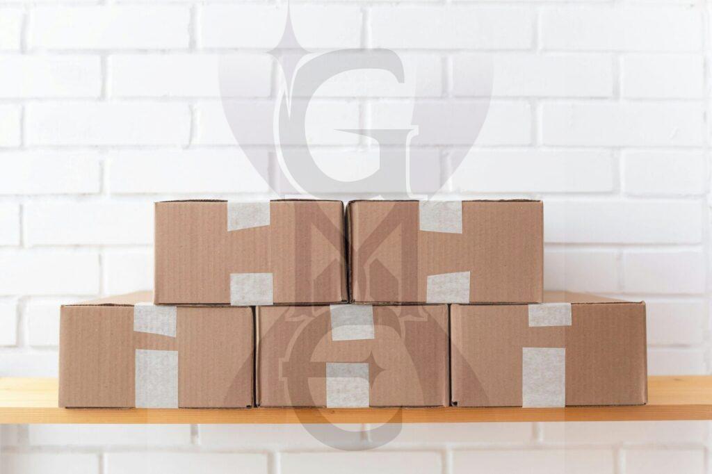 Photo by Ayrat A neat stack of cardboard boxes taped and placed on a wooden shelf against a white brick wall.